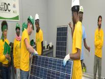 A group of people examining a solar panel